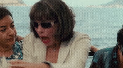 A Woman Wearing Sunglasses Is Sitting On A Boat With Other People GIF