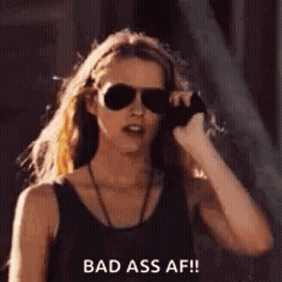 A Woman Wearing Sunglasses Is Talking On A Cell Phone And Says `` Bad Ass Af '' . GIF
