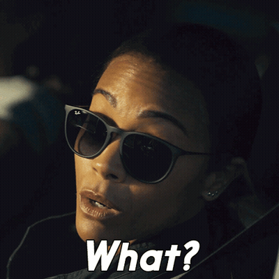 A Woman Wearing Sunglasses Says " What " In White Letters GIF
