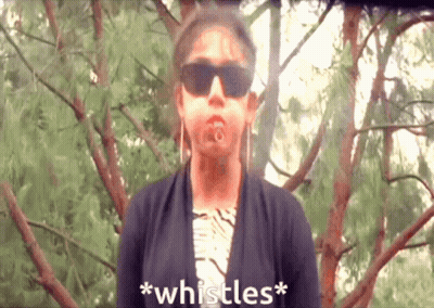 A Woman Wearing Sunglasses Says * Whistles * In Front Of Some Trees GIF