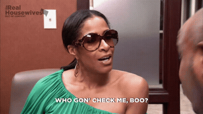 A Woman Wearing Sunglasses Says " Who Gon ' Check Me Boo " In Front Of A Real Housewives Logo GIF