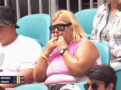 A Woman Wearing Sunglasses Sits In A Stadium Watching A Game Between Medvedev And Nurkacz GIF
