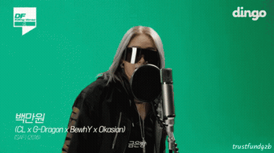 A Woman Wearing Sunglasses Stands In Front Of A Microphone With Dingo In The Corner GIF