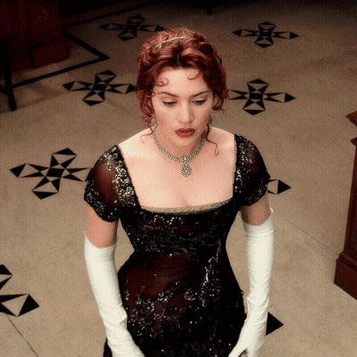 A Woman Wearing White Gloves And A Black Dress GIF