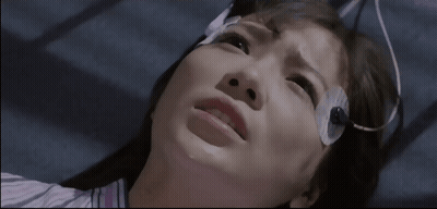 A Woman With A Bandage On Her Head Looks Up At The Camera GIF
