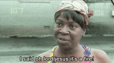 A Woman With A Bandana On Her Head Is Saying I Said Oh Lord Jesus It 'S A Fire ! GIF