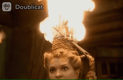 A Woman With A Basket Of Flames On Her Head Is Displayed On A Doublecat Website GIF