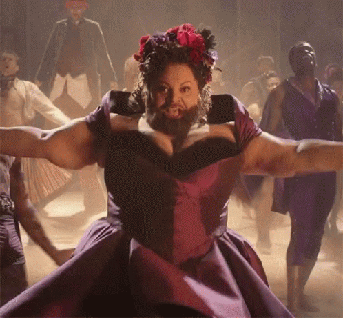 A Woman With A Beard In A Purple Dress Is Dancing GIF