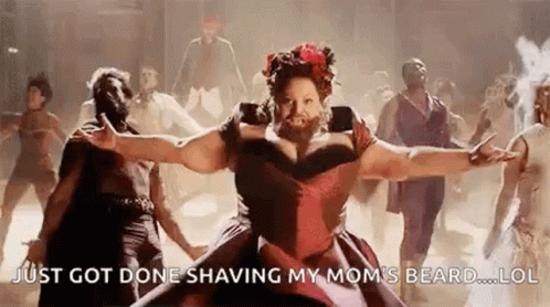 A Woman With A Beard Is Dancing With A Group Of People . GIF