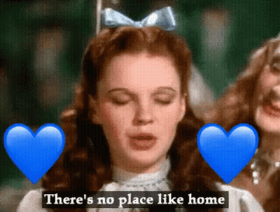 A Woman With A Blue Bow On Her Head Is Surrounded By Blue Hearts And The Words " There 'S No Place Like Home " GIF
