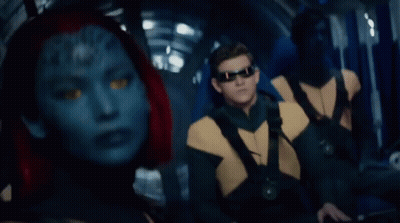 A Woman With A Blue Face And Red Hair Looks At The Camera GIF
