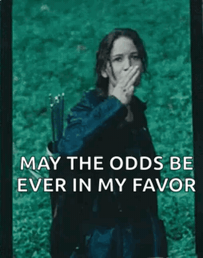 A Woman With A Bow And Arrow Is Covering Her Mouth With Her Hand And The Words May The Odds Be Ever In My Favor GIF