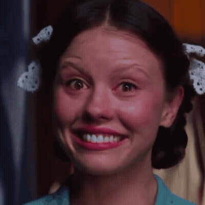 a woman with a bow in her hair is smiling and making a funny face