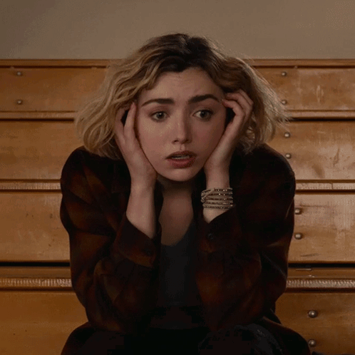 A Woman With A Bracelet On Her Wrist Covering Her Face GIF