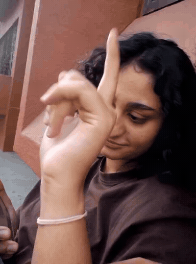 A Woman With A Bracelet On Her Wrist Is Giving A Thumbs Up Sign GIF