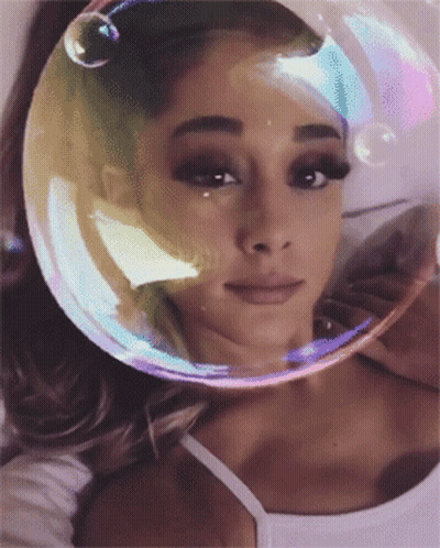 A Woman With A Bubble On Her Head Looks At The Camera GIF