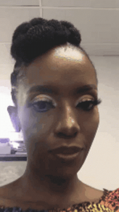 A Woman With A Bun On Her Head Is Making A Funny Face . GIF