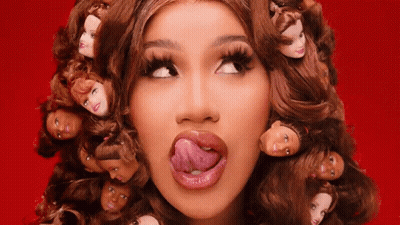 A Woman With A Bunch Of Barbie Doll Heads In Her Hair GIF