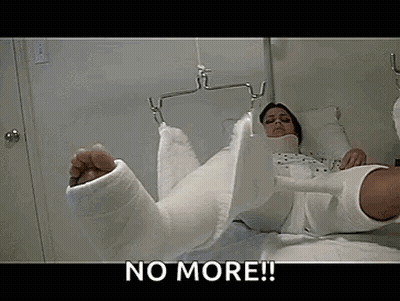 A Woman With A Cast On Her Leg Is Laying On A Bed . GIF