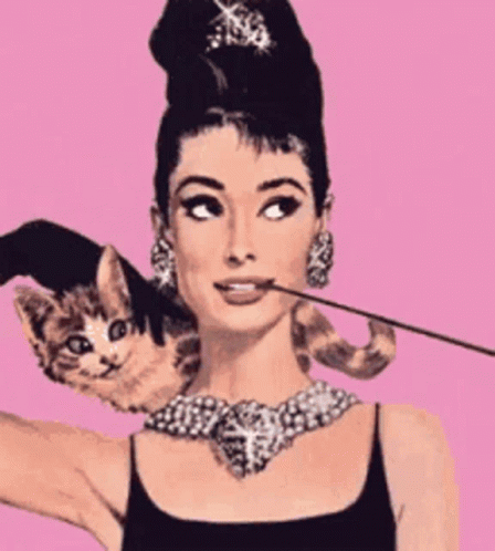 A Woman With A Cat On Her Shoulder Holding A Cigarette In Her Mouth GIF