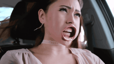 A Woman With A Choker Around Her Neck Is Sitting In A Car With Her Mouth Wide Open GIF