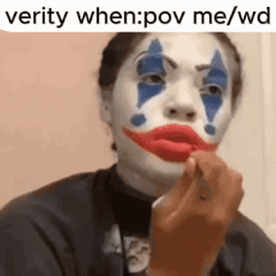 A Woman With A Clown Face Painted On Her Face . GIF
