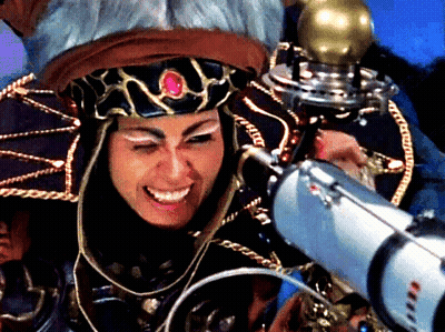 A Woman With A Crown On Her Head Is Smiling While Holding A Silver Object GIF