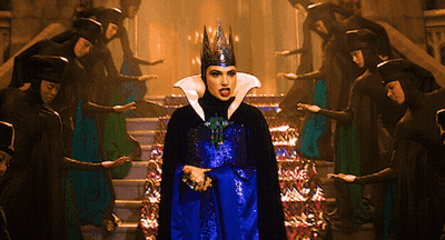 A Woman With A Crown On Her Head Stands In Front Of A Group Of People GIF