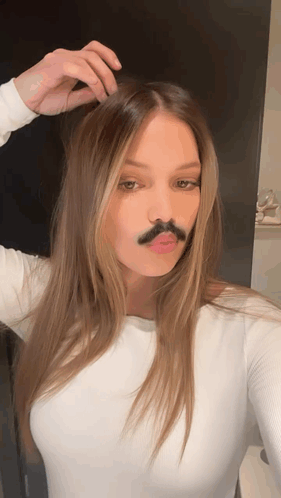 A Woman With A Fake Mustache On Her Face Takes A Selfie GIF