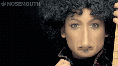 A Woman With A Fake Nose Is Holding A Guitar And Making A Face GIF