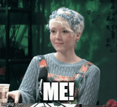 A Woman With A Flower Crown On Her Head Is Sitting In Front Of A Microphone And Says Me GIF