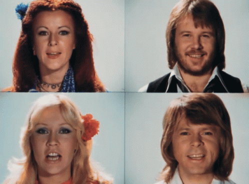 A Woman With A Flower In Her Hair And A Man With A Beard Smile For The Camera GIF