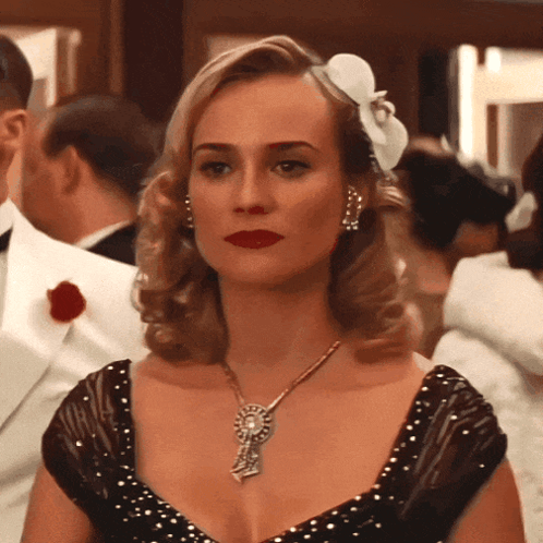 A Woman With A Flower In Her Hair Wears A Necklace GIF