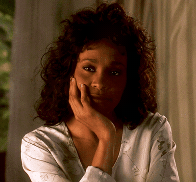 A Woman With A Hand On Her Face Looks At The Camera GIF