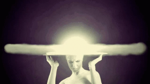 A Woman With A Light Coming Out Of Her Head Holds Her Hands To Her Head GIF