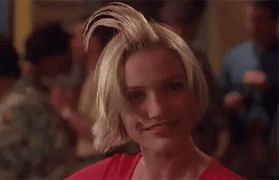 A Woman With A Mohawk Is Smiling And Looking At The Camera In A Crowded Room . GIF