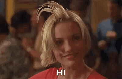 A Woman With A Mohawk On Her Head Is Smiling And Says Hi . GIF