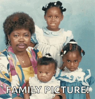 A Woman With A Mustache Is Holding A Baby And Two Girls With The Words Family Picture Below Them GIF