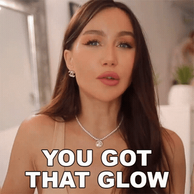 A Woman With A Necklace And Earrings Says You Got That Glow GIF