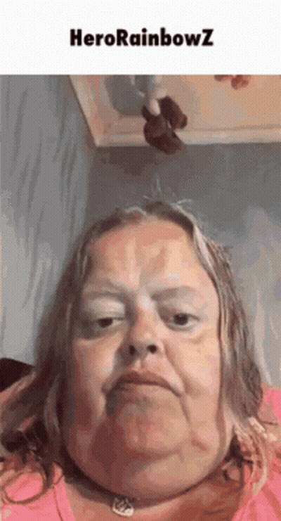 A Woman With A Necklace Around Her Neck Is Making A Funny Face With The Words Herorainbowz Above Her . GIF