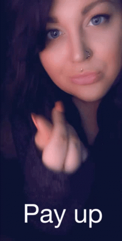 A Woman With A Nose Ring And A Pay Up Sign Below Her GIF