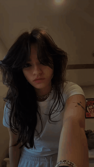 A Woman With A Nose Ring And A Tattoo On Her Arm GIF