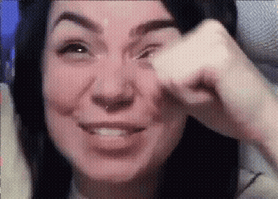A Woman With A Nose Ring Is Crying While Holding Her Hand To Her Eye . GIF