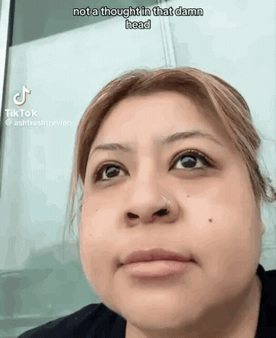 A Woman With A Nose Ring Is Making A Funny Face While Looking Up . GIF