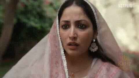 A Woman With A Nose Ring Is Wearing A Pink Veil And Earrings . GIF