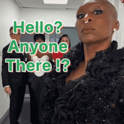 A Woman With A Nose Ring Stands In Front Of A Sign That Says Hello Anyone There ! GIF