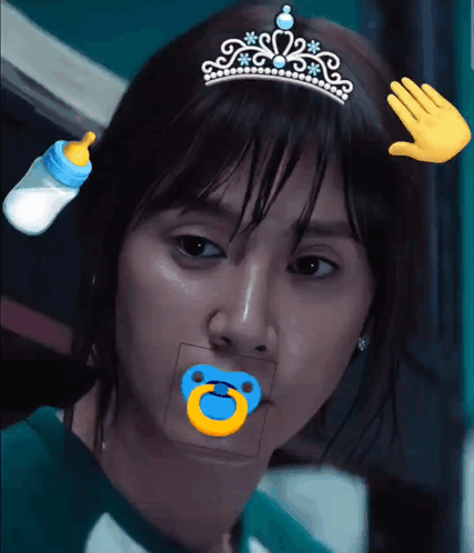 A Woman With A Pacifier In Her Mouth Wearing A Tiara GIF