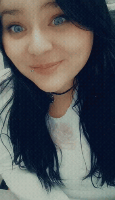 A Woman With A Piercing In Her Lip Is Smiling GIF