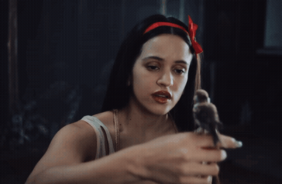 A Woman With A Red Bow In Her Hair Holds A Small Bird In Her Hand GIF