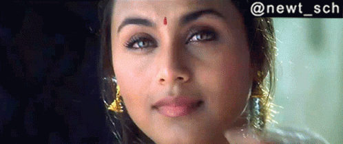 A Woman With A Red Dot On Her Forehead Is Smiling GIF